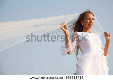 Young bride is holding her flying veil