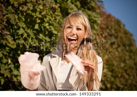 Happy girl in early autumn park with candy-floss