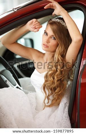 Young sensual bride sits in the red car.Selective focus.Professional hair and make -up