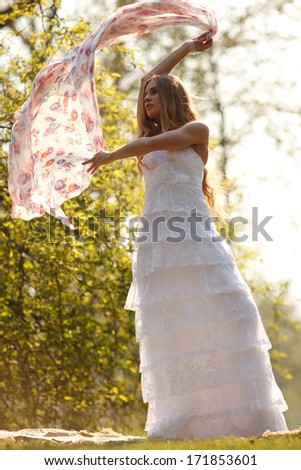Bride in hippie style stands outdoors in the spring park