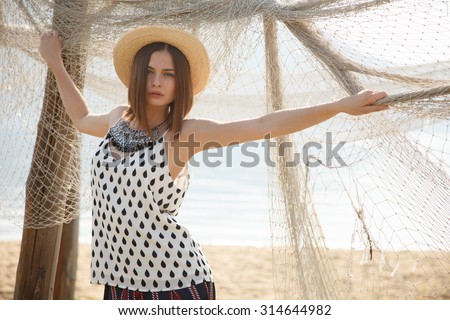 Young fashion model in straw hat  with the seine outdoors near river. Professional styling,hairs, make-up.