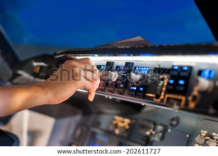 fingers controls the switch control panel in a plane cockpit