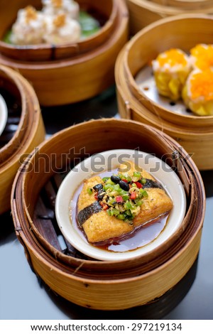 yumcha,tofu shumai dim sum topping with bird chili in bamboo steamer of chinese restaurant