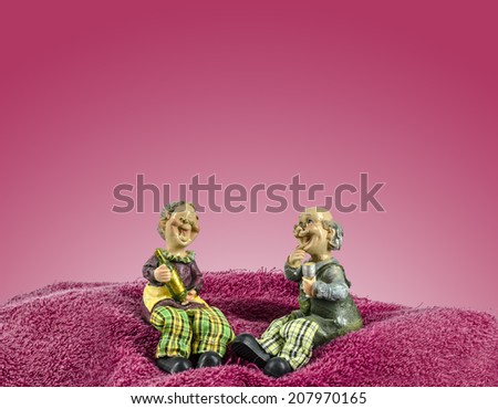Two dolls which made like grand mom & grand dad sit on towel mountain