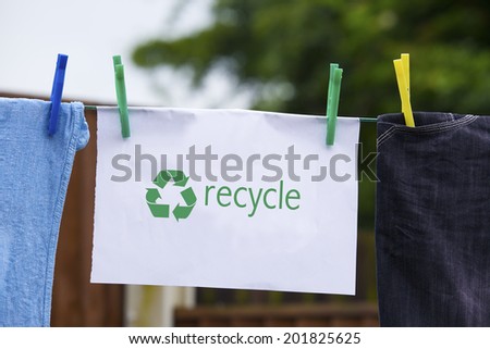 Clothes pegged on a washing line with recycle sign.