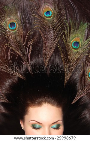 Beautiful brunette long hair decorated with peacock feathers