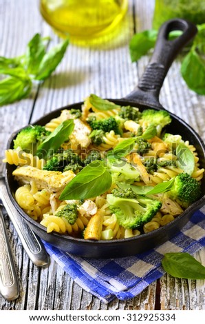Fusilli with chicken,broccoli and basil pesto in a skillet pan.
