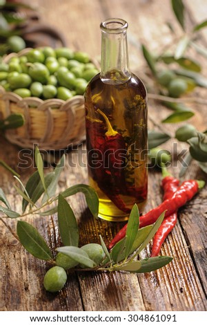 Olive oil with spices and herbs on wooden background