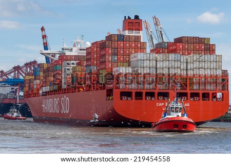Hamburg, Germany - June 23, 2014: Tug boat pulls large container ship in the port of Hamburg