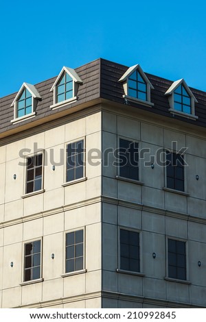 Classical Lofts and Windows Against Blue Sky, with One Side Illuminated by The Sun and The Other Side in Shadow.