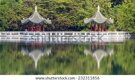 The Twin Lotus Pavilion with Tourists in The Forest, With Reflections from The Green Lake, Located  in Cheng Ching Lake, Kaohsiung, Taiwan.