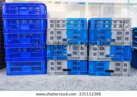 Pile of Plastic Pallets of Blue And Gray Color Stacked Beside  A Convenience Store.