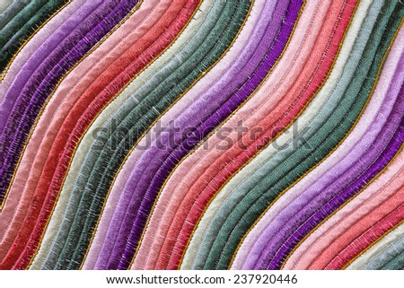 Close Up of A Cloth With Embroidery of Chinese Pattern of Wavy Stripes of Green, Purple And Red Color. It Is Used To Decorated The Lap of Robes Worn By The Officers of Qing Dynasty.