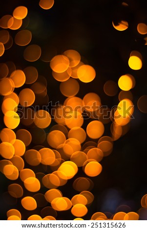 Abstract Background of Defocused Light Spots of Orange Color in Dark Background. Looks like many flame of candles.