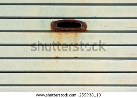 An Old Steel Shutter Door With A Hole of Handle to Pull It Up. Mails Also Can be Inserted Through The Hole.