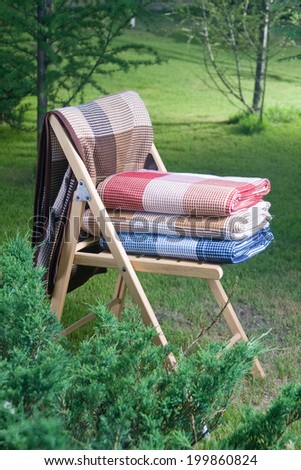 photo blankets folded on a chair outdoors