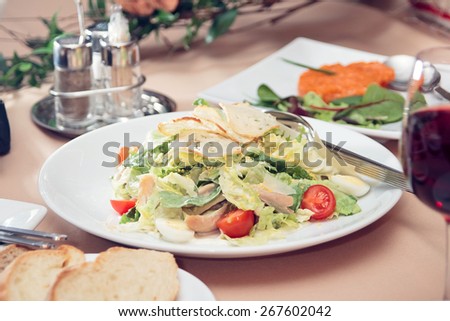 Healthy fresh salad on white plate in restaurant