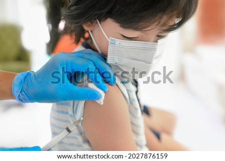 Asian child being vaccinated.Children vaccination by nurse.Medical doctor vaccinating school student in the arm.Paediatrician administrating vaccine to students in clinic.Physician injecting person.
