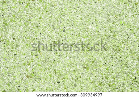 Abstract background of exposed aggregate concrete texture light green color