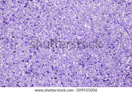 Abstract background of exposed aggregate concrete texture purple color