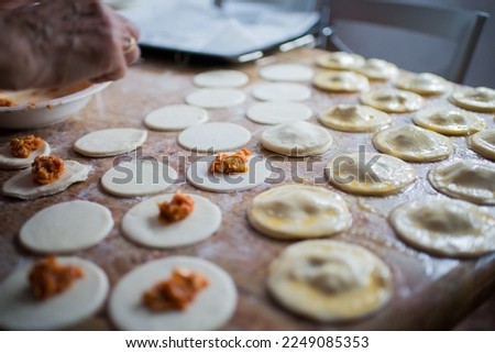 Similar – Image, Stock Photo Filling and sealing puff pastry dumplings in a kitchen