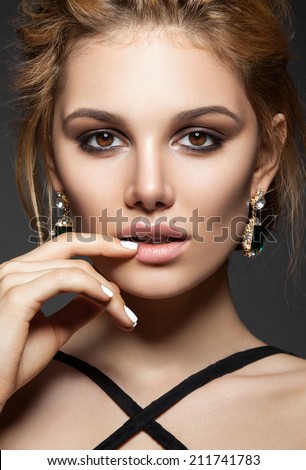 Beautiful girl model with perfect skin, evening make up and white color nails.
