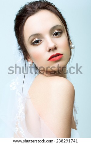 Portrait of beautiful bride with wedding make up and hairdo. Red lips.