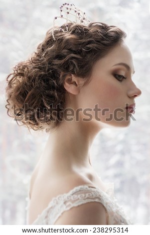 Portrait of the bride with wedding make up and trendy hairdo on white background
