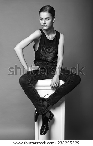 Beautiful young model with natural make-up in black unisex clothes. Androgyne young woman. Black and white test photo