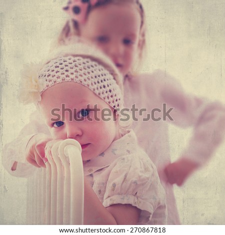 Art photo. Portrait of beautiful little girls (sisters)  in vintage style. The image is tinted, blurring and selective focus.