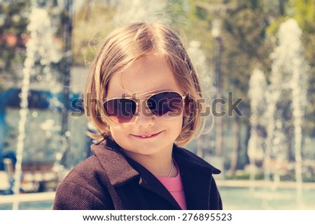 Beautiful little girl in sunglasses. The image is tinted.