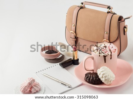 Hot chocolate with marshmallows and women\'s  fashion accessories on a white background. Selective focus.