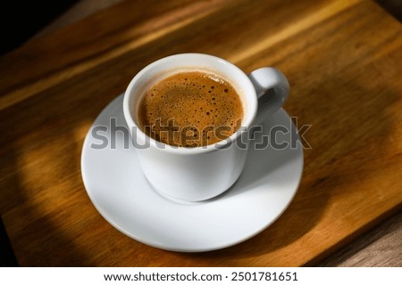 Image, Stock Photo White coffee cup on white coaster on wooden table. Coffee foam with latte Art.