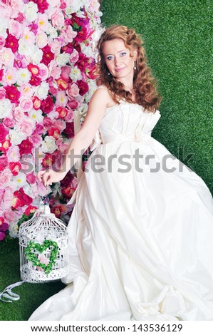 Young beautiful bride lying on the green grass