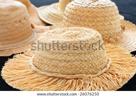 Collection of straw hats on black background