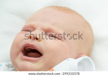 small baby crying and smiling on white