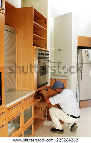 Worker of the construction arming an integral kitchen