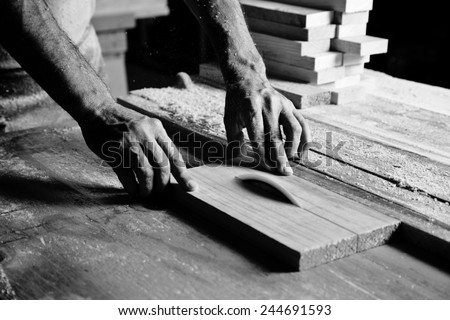 hands of the craftsman cut a piece of wood