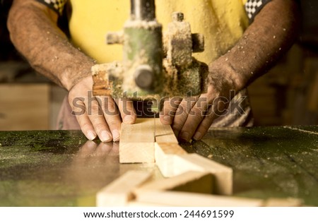 Man\'s hand detail cutting wood at the industry of the manufacture.