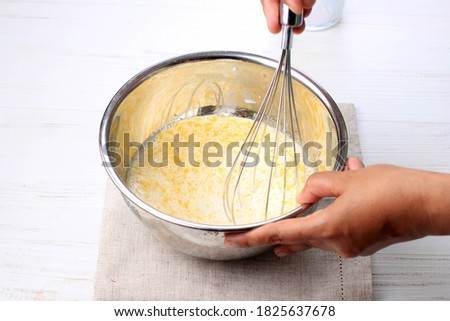 Mix Milk with Melted Butter and Egg using Baloon WHisk on Stainless Bowl  Foto stock © 