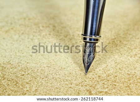 Closeup of an elegant fountain pen on vintage grunge background