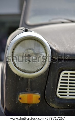 Closeup of the headlight of an old style car that invokes memories