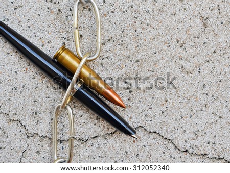 Pen chain and bullet placed on a wall with fissure