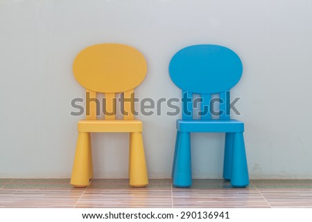 chair on wall background, simple interior with a yellow stool and copy space on the wall, 2 chair on wall