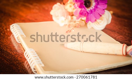Vintage,retro of note book paper and pen on wooden background soft focus.