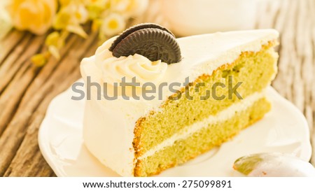 Green tea cream vanilla cake on wooden background soft focus vintage tone.
