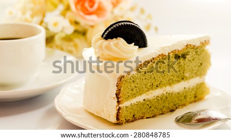 Green tea with vanilla cream cake on white background soft focus.