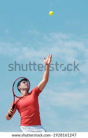 Young tennis player with racket throws the ball prepares to serve at beginning of game or match. Cute male tennis player athlete in action. Competitive sport. Vertical banner Copy space