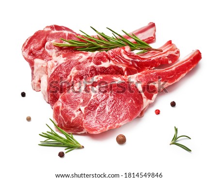 Three pieces of mutton meat with herbs and mixed peppers isolated on white background. Mutton steaks with rosemary.