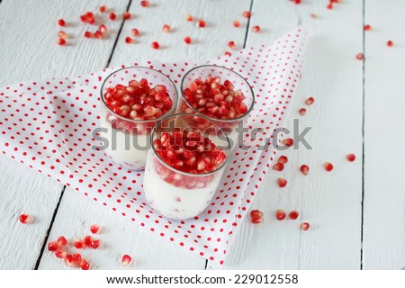 Healthy gluten free panna cotta dessert with  pomegranate seeds in jars perfect for breakfast or christmas holidays